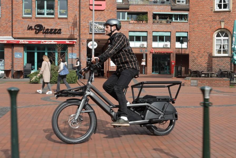 Das Bild zeigt ein Specialized Turbo Porto 3 E-Bike, das in einer belebten Innenstadt fährt.