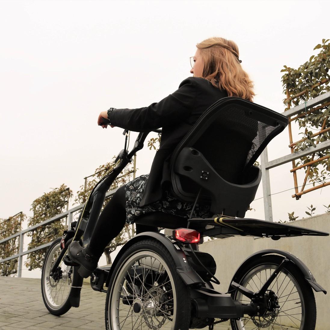 Eine Frau fährt einen Berg auf dem vanRaam Easy Rider Dreirad hoch