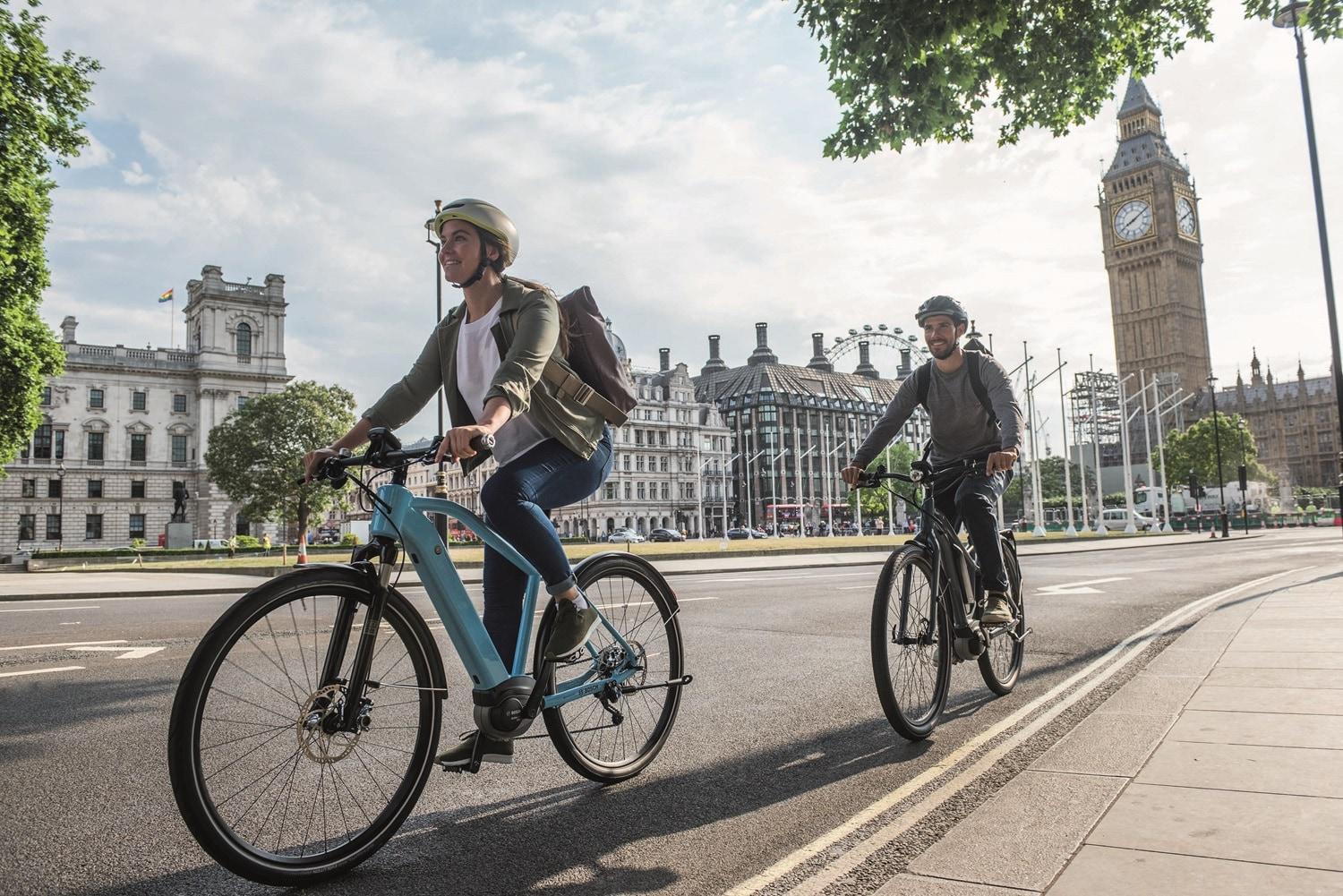 Zwei e-Bikende fahren durch die Stadt