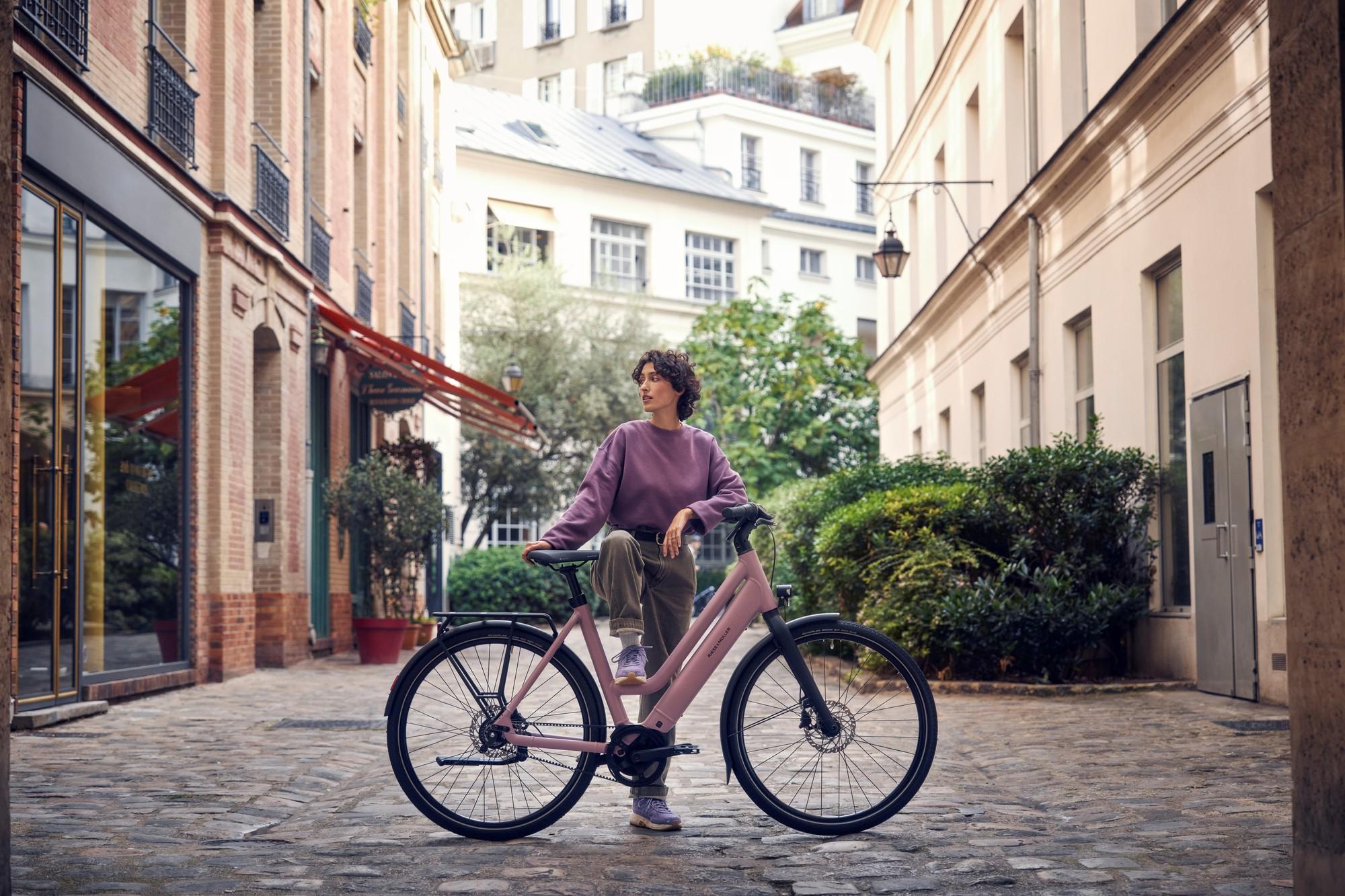 Das Bild zeigt ein Riese und Müller Culture Mixte E-Bike, das in einer malerischen, urbanen Umgebung steht.