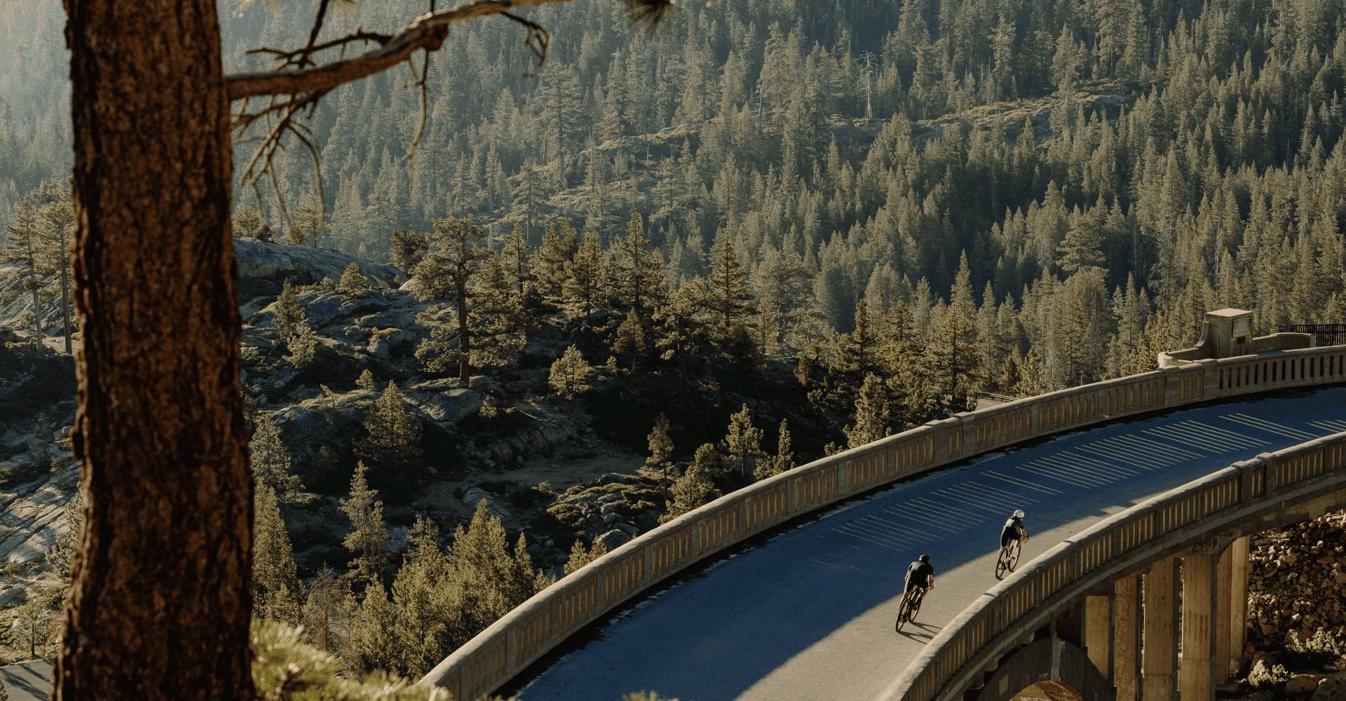 Zwei Personen fahren mit den Specialized Turbo Creo e-Bikes über eine Brücke