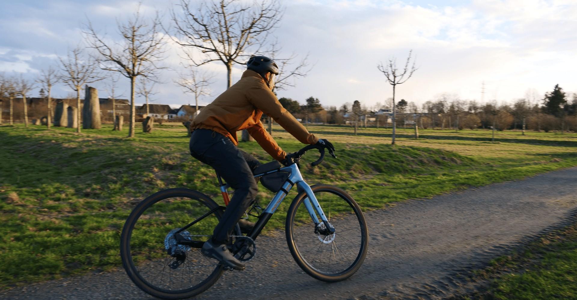 Marcel testet das Mondraker Dusty im Gelände und fährt über einen Schotterweg