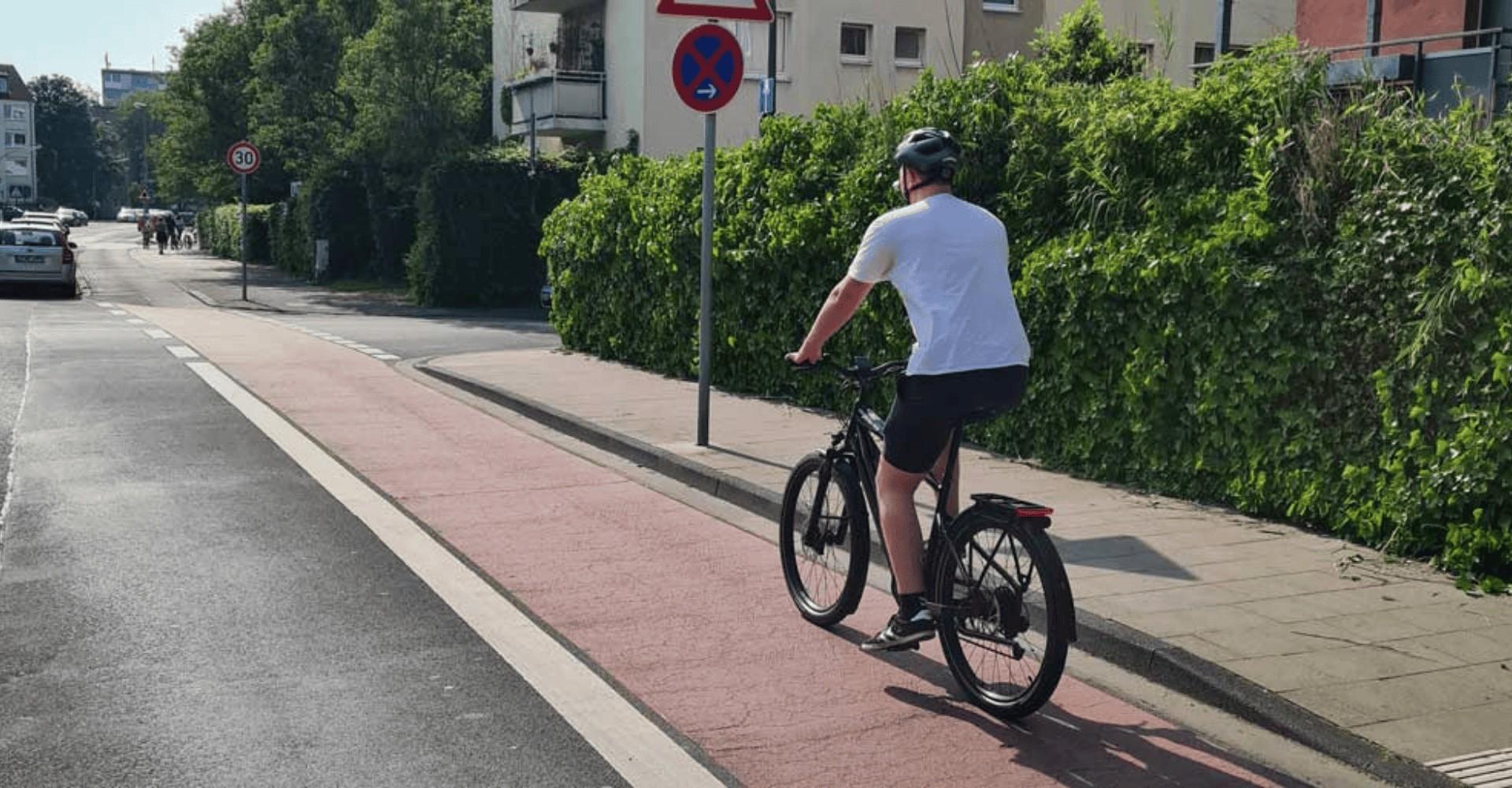 Ein Mann fährt auf dem e-Bike einen Fahrradweg entlang