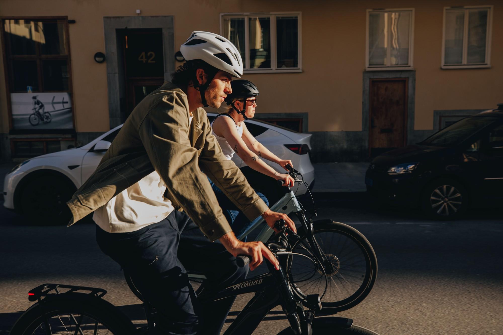 Zwei Mitarbeiter fahren auf Specialized e-Bikes durch die Stadt.