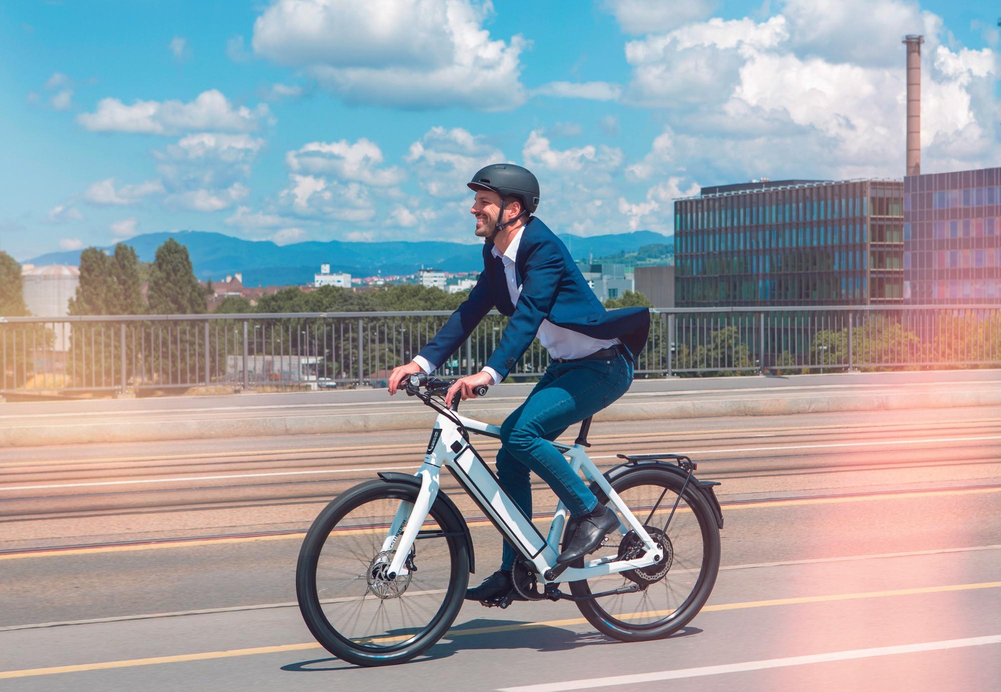 Ein Mann in Anzug fährt auf Stromer ST2 e-Bike die Brücke entlang