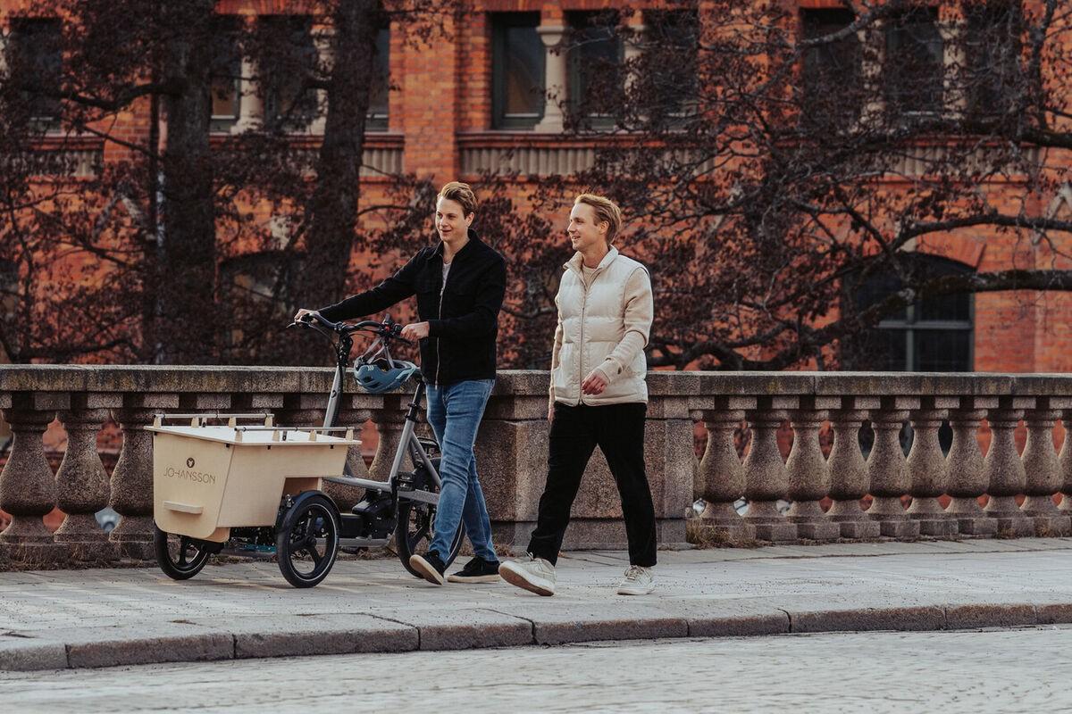 Zwei Männer schieben das Johansson Lasten e-Bike über eine Brücke