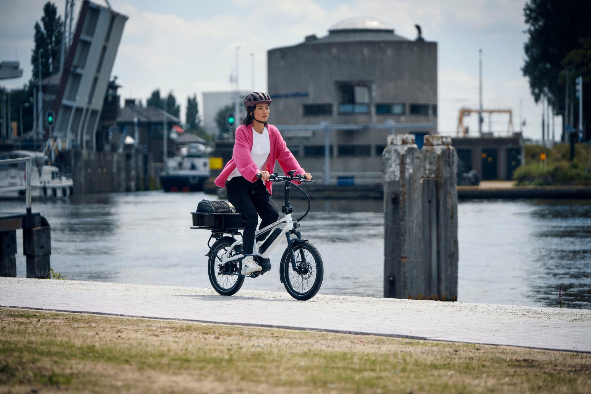 Entdecken Sie das Tinker 2023 E-Bike in Aktion. Perfekt für urbane Mobilität und stilvolles Fahren entlang malerisc