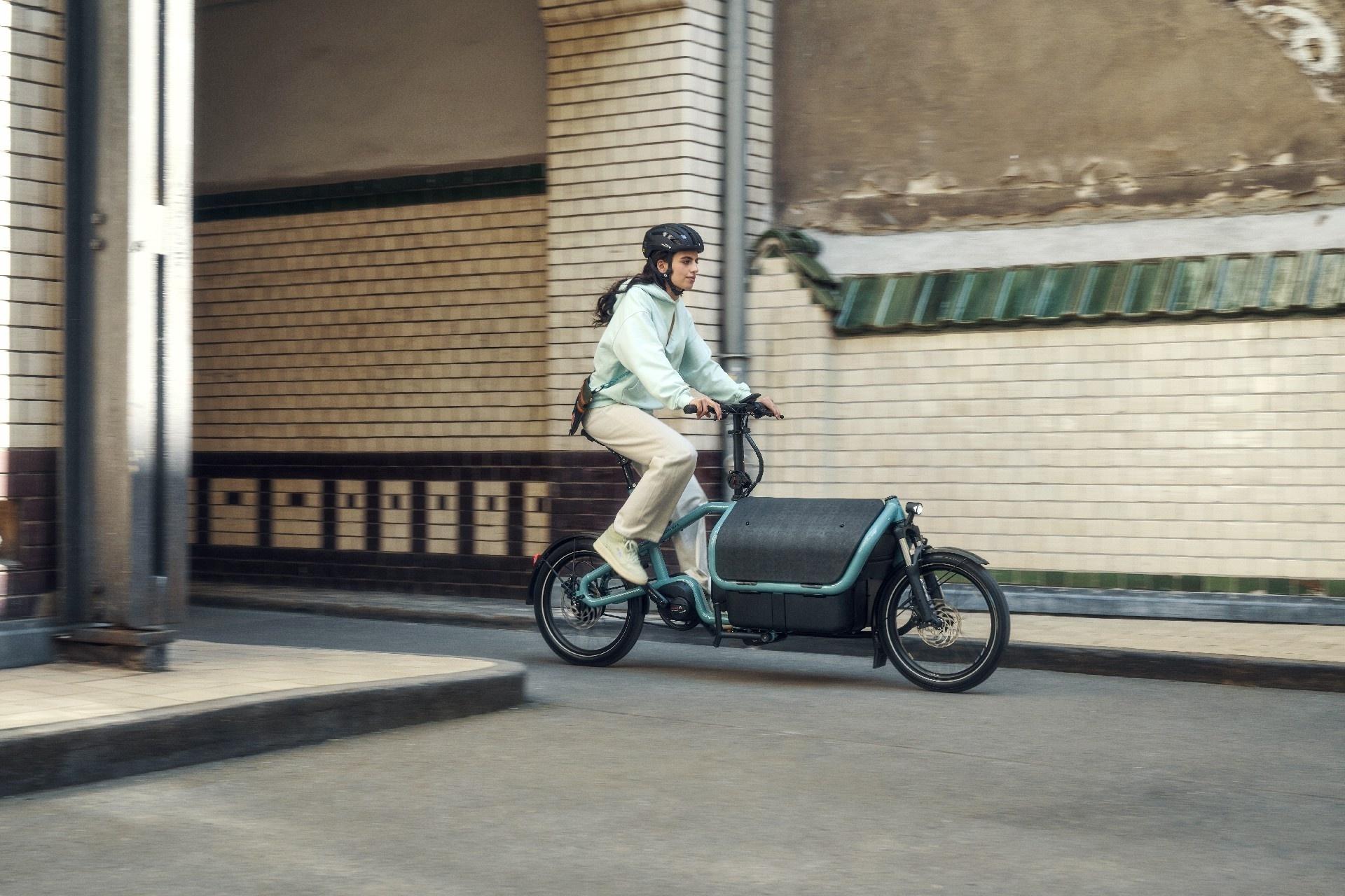 Eine Frau fährt auf dem Riese & Müller Carrie durch einen Tunnel in urbaner Umgebung