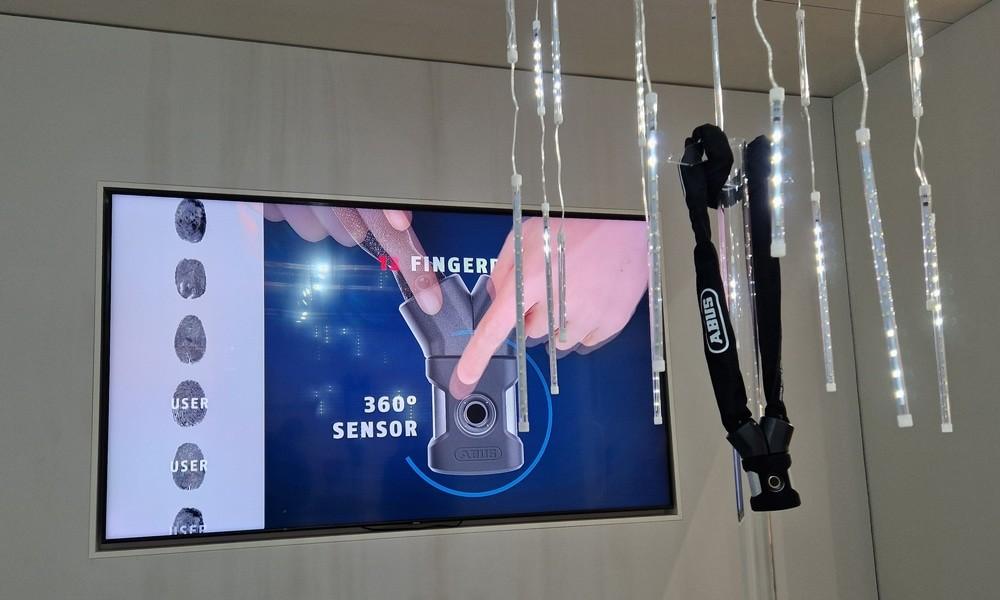 ABUS zeigt 360° e-Bike-Sensor mit Fingerabdruckscanner, Fokus auf smarte Sicherheitstechnologie.