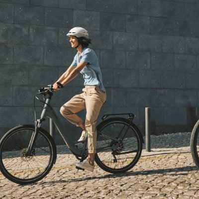 Zwei Personen fahren E-Bikes auf gepflastertem Weg in Wien