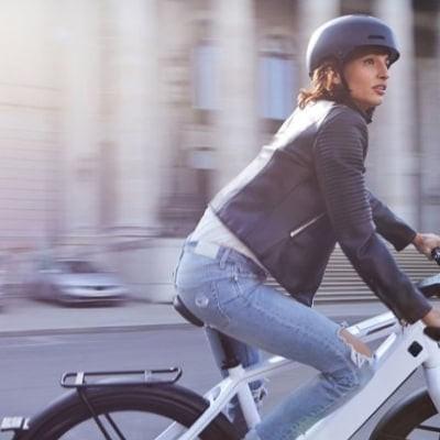 Frau auf weißem Speed-Pedelec in der Stadt