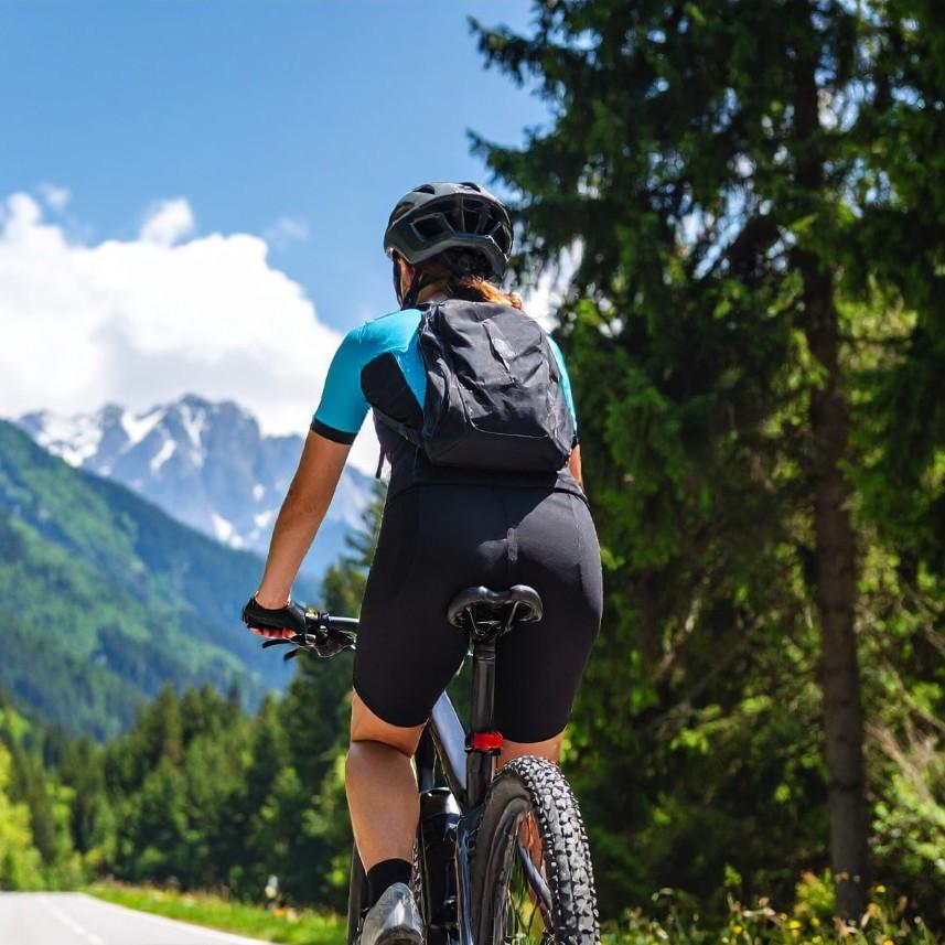 Ein Radfahrer genießt eine Fahrt durch eine atemberaubende Berglandschaft. Perfekt für Outdoor-Enthusiasten, die Na