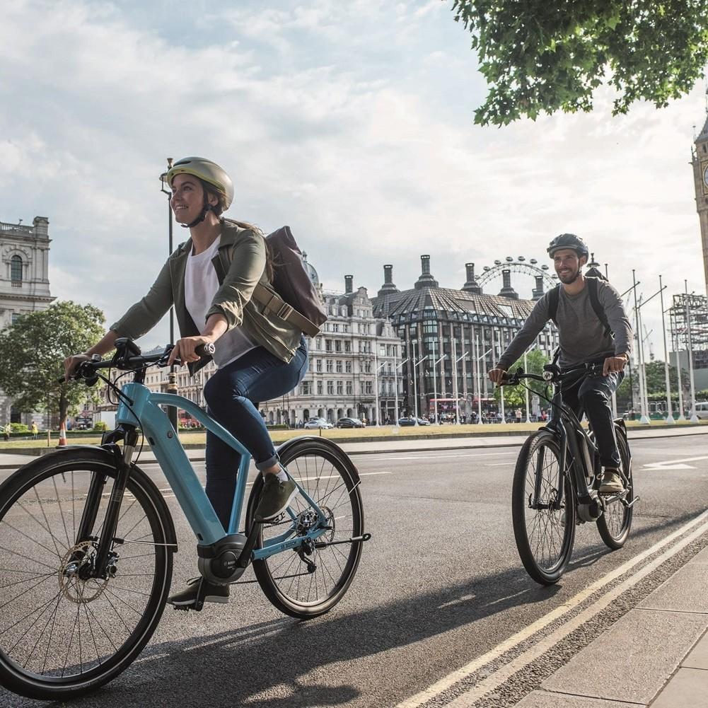 Zwei e-Bikende fahren durch die Stadt