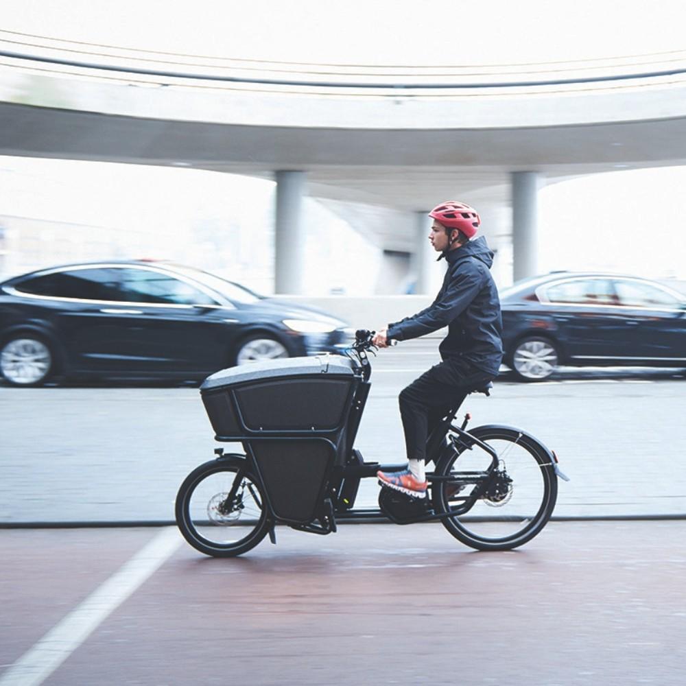 Im Rahmen der Lastenrad Förderung in Frankfurt fÀhrt ein Mann mit einem Lastenrad gerade durch die Stadt.