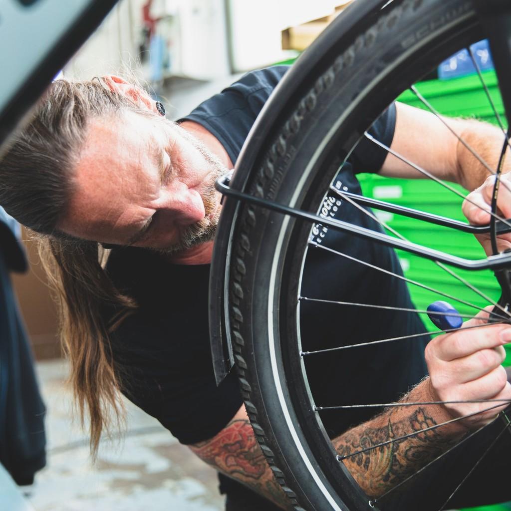 Ein Techniker wartet ein Fahrradrad in einer Werkstatt in Heidelberg. Perfekt für professionelle Reparaturen und Wa