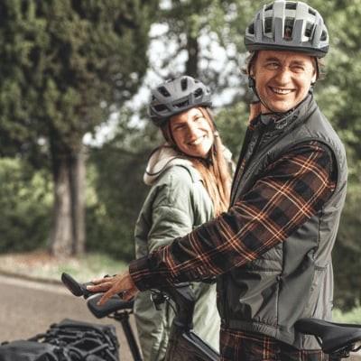 Zwei Personen mit Fahrrädern auf einer Landstraße, Radlobby Wien Logo