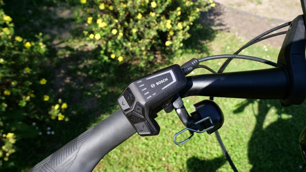 Das Bild zeigt eine Steuerungseinheit für ein E-Bike, die am Lenker montiert ist.