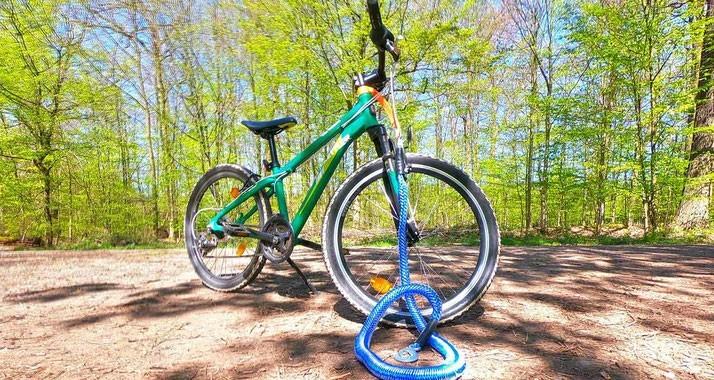 Das Bild zeigt ein e-Bike, das auf einem Waldweg abgestellt ist. Im Vordergrund ist ein Abschleppseil zu sehen.