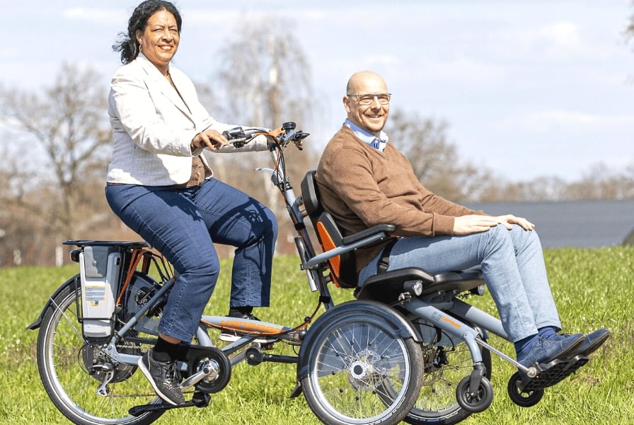 Duo-Fahrrad mit zwei Personen auf grüner Wiese