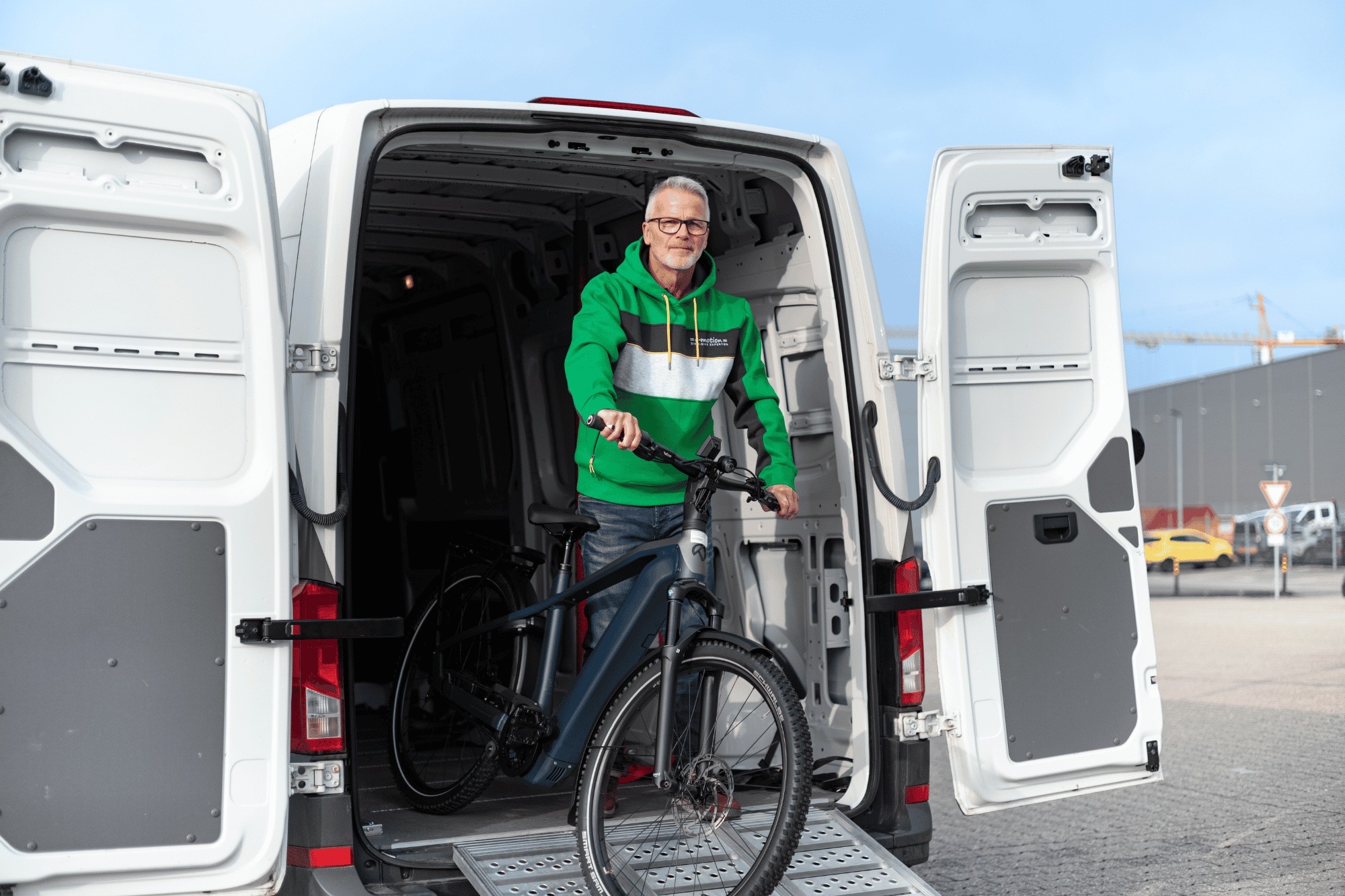 Ein Mann mit e-Bike im Transporter, Hol- und Bringservice von e-motion