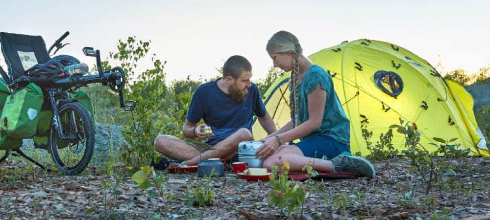 Ein Mann und eine Frau zelten mit einem HASE BIKES Pino