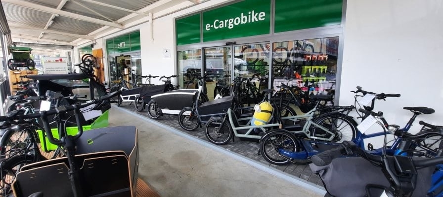E-Cargobike Geschäft mit verschiedenen Lastenrädern vor dem Laden