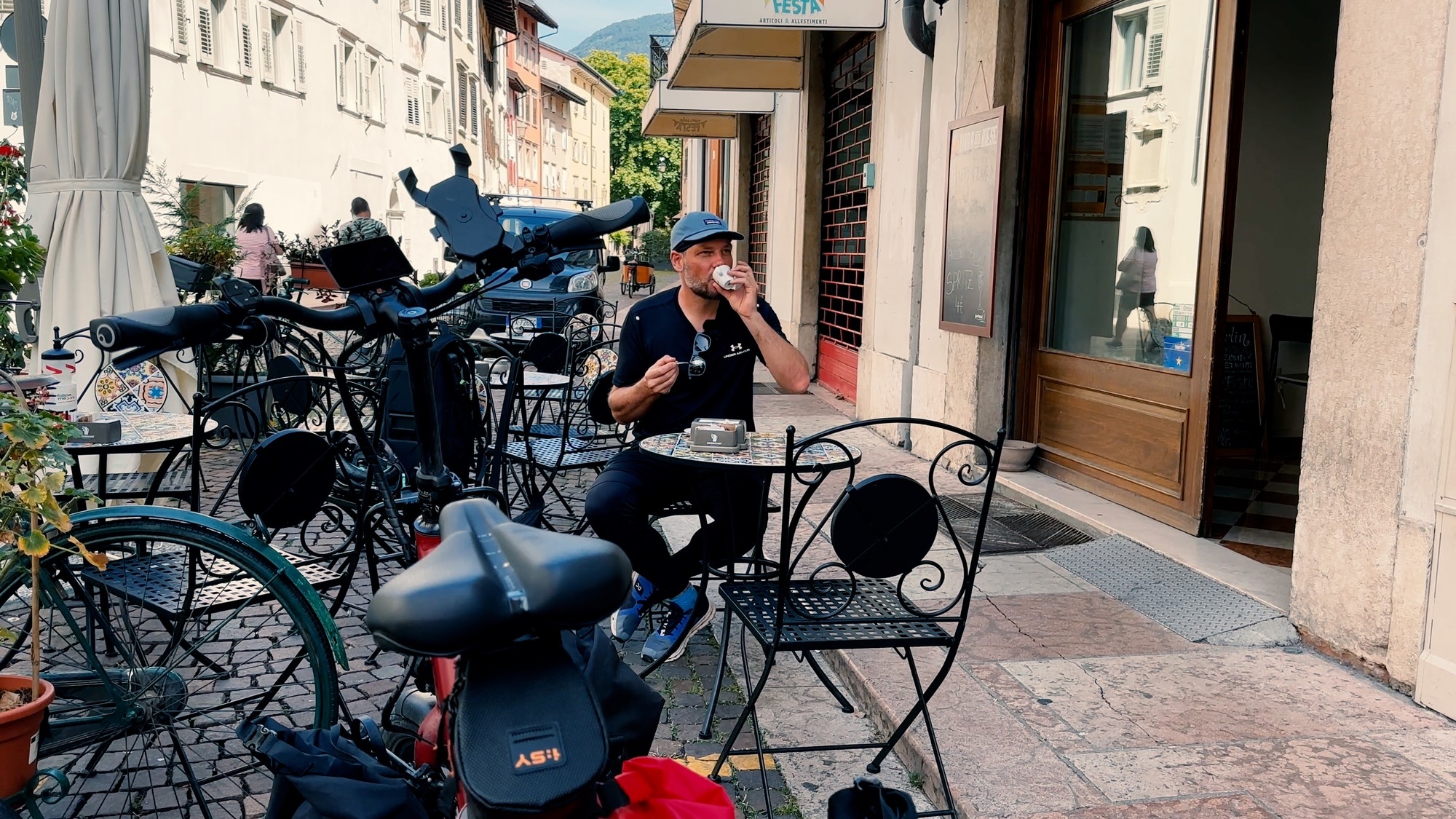 Das Bild zeigt einen Mann der in Trient einen Kaffee trinkt