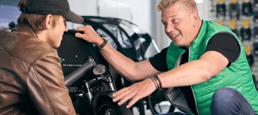 Zwei Männer betrachten ein E-Bike in einem Geschäft