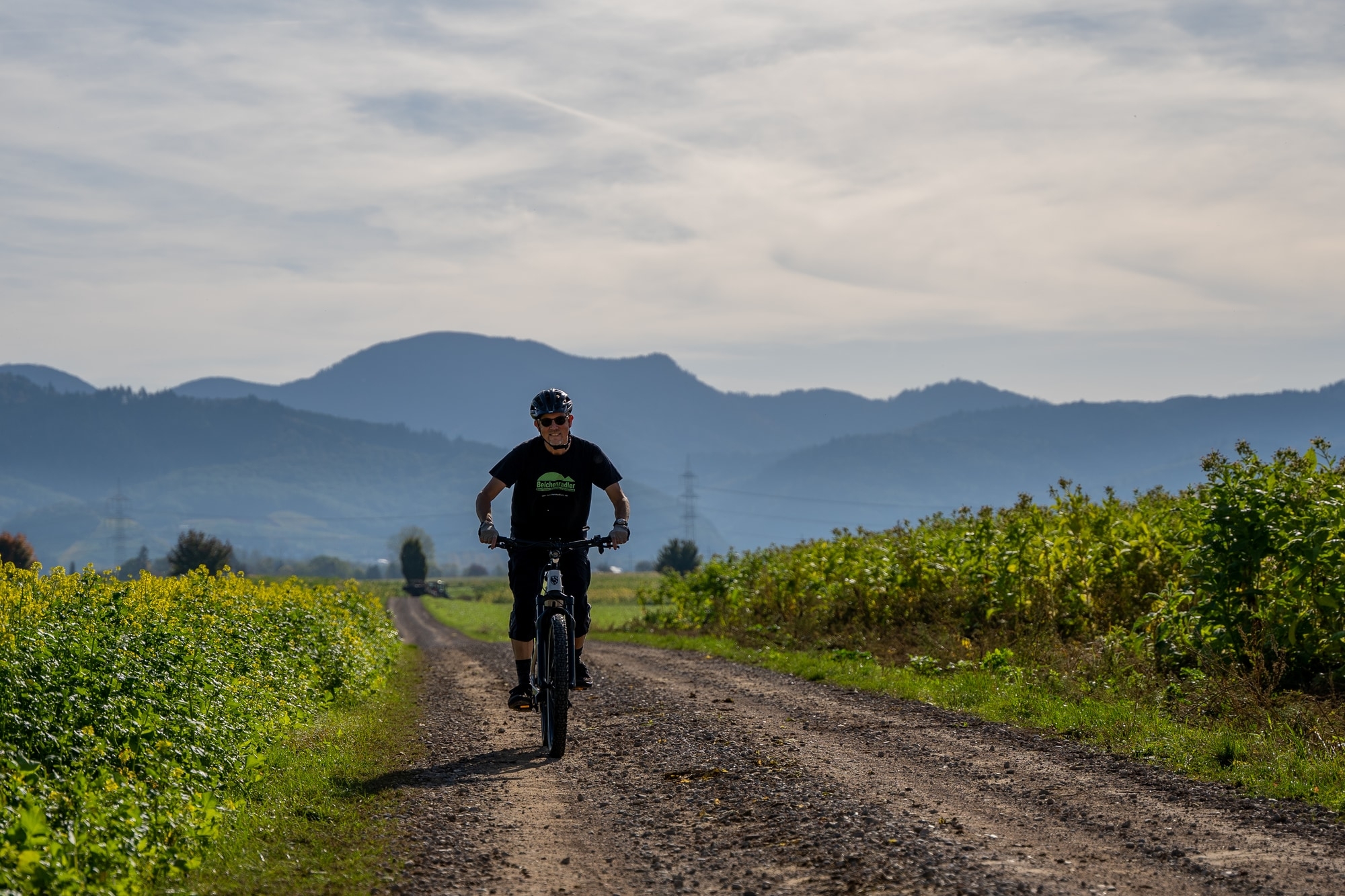 Der Fahrer genießt mit seinem Hercules Nos SUV4 E-Bike eine Offroad-Tour in der idyllischen Landschaft. Perfekt für