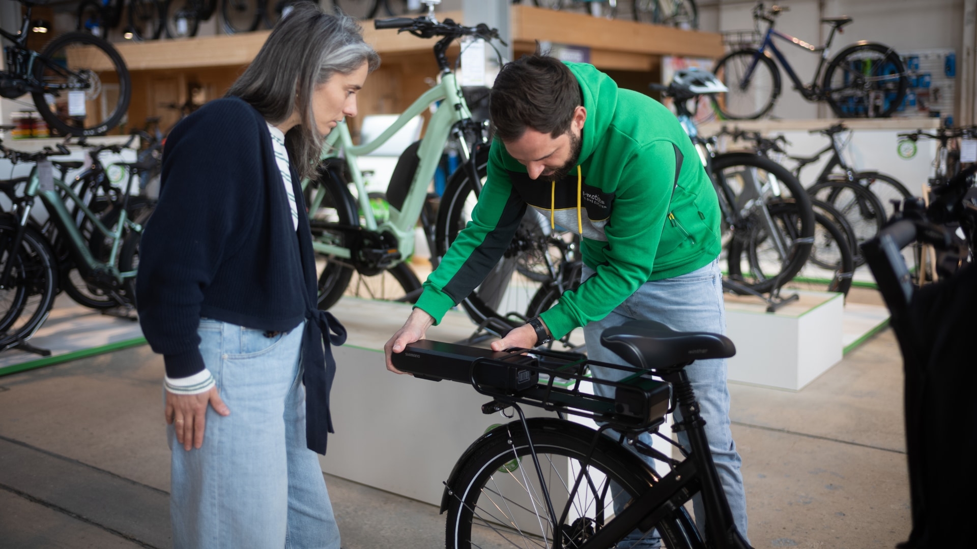Ein e-motion Mitarbeiter zeigt die sichere Entnahme eines E-Bike Akkus. Perfekt für E-Bike-Besitzer, die Wert auf Q