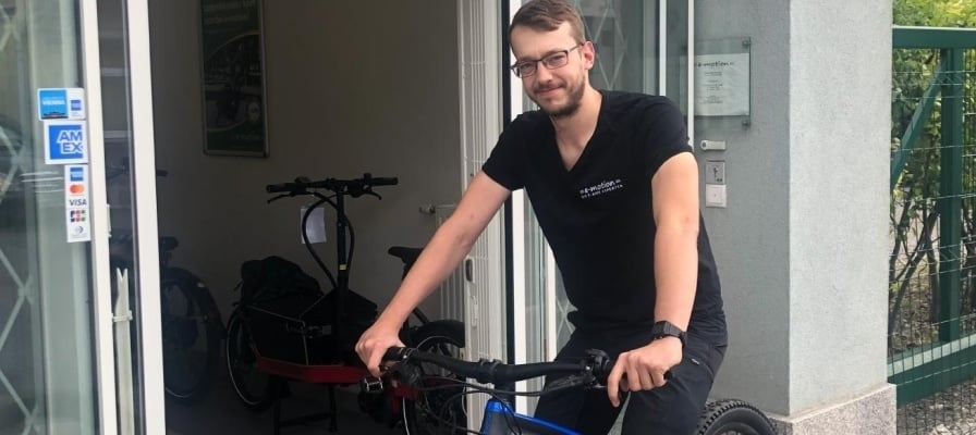 Mann mit E-Bike vor einem Geschäftseingang