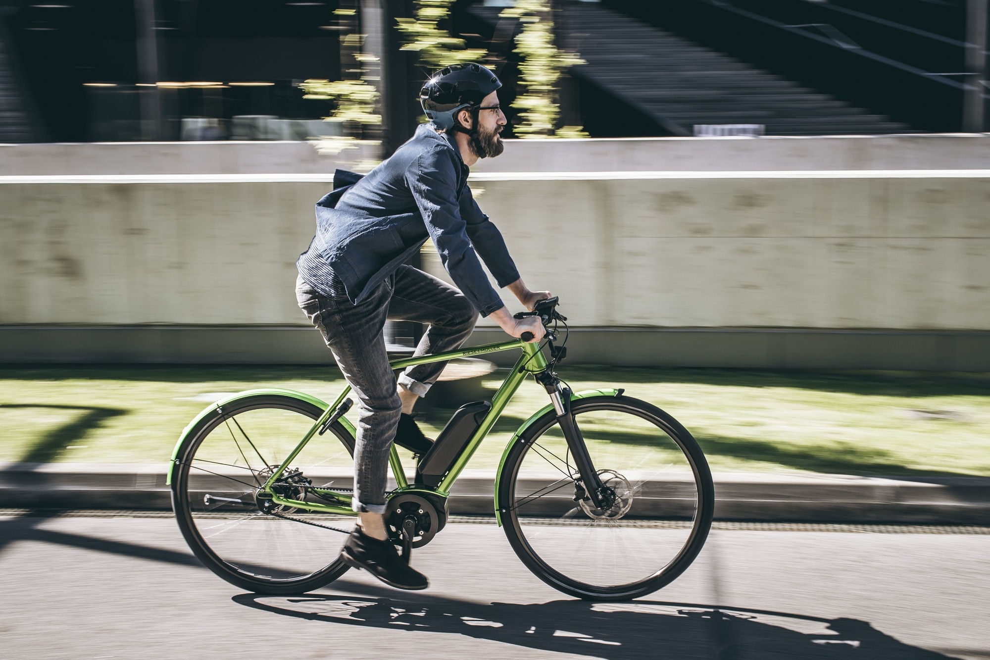 Das Bild zeigt einen Radfahrer, der auf einem E-Bike des Modells Riese & Müller Roadster fährt.