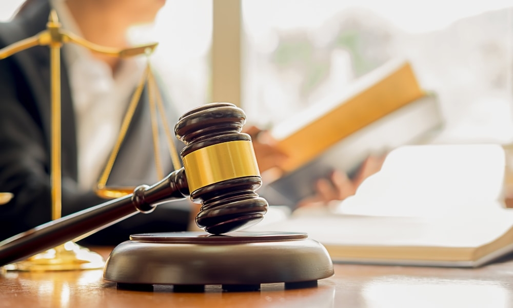 Ein Richterhammer aus Holz auf einem Schreibtisch, ideal für Kanzleien oder juristische Dekorationen.