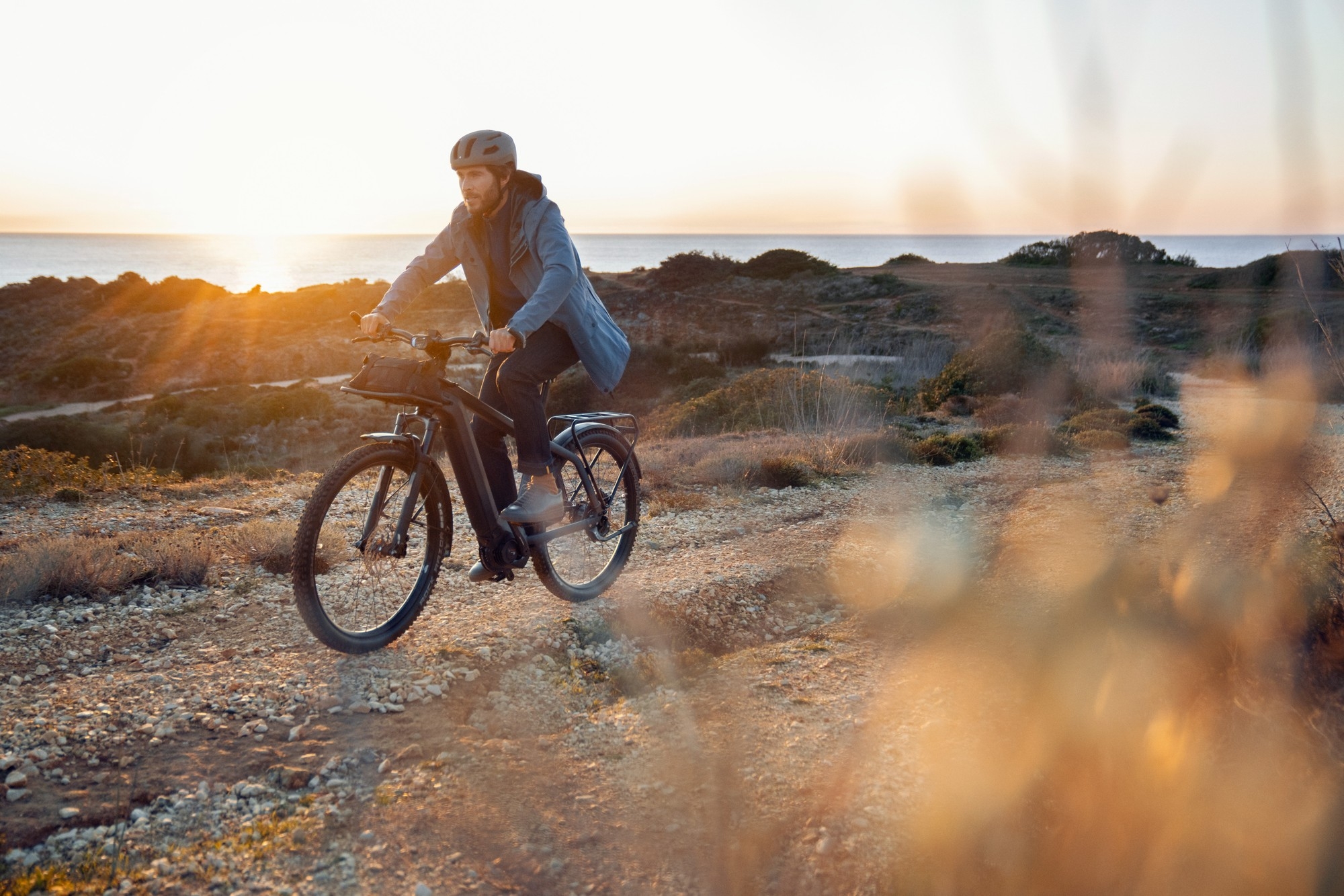 Das Bild zeigt ein Riese & Müller Charger e-Bike, dass bei Sonnenuntergang gefahren wird.